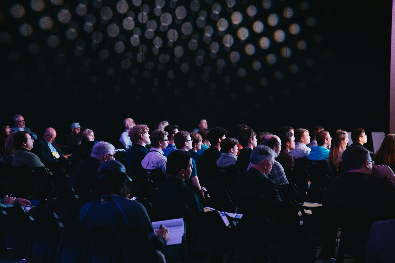 Audience at a live briefing in a darkened hall
